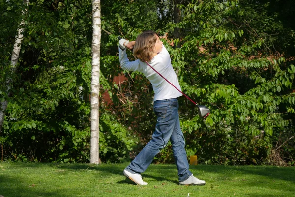 Jovem jogador de golfe com motorista teeing-off — Fotografia de Stock