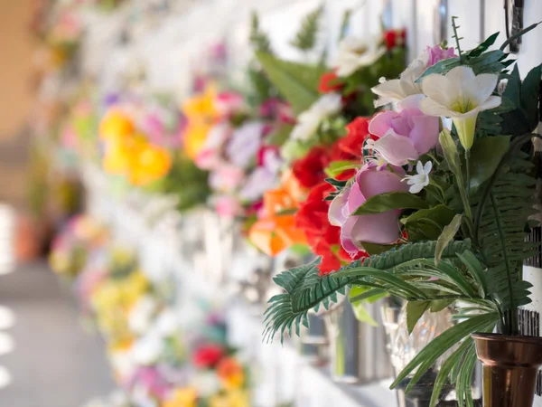 Túmulos com flores em uma parede de um cemitério europeu . — Fotografia de Stock