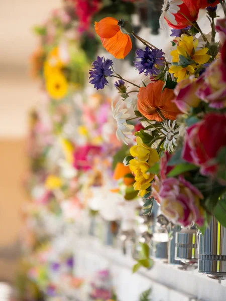 Túmulos com flores em uma parede de um cemitério europeu . — Fotografia de Stock