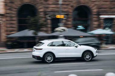 Ukrayna, Kyiv - 2 Haziran 2021: Beyaz Porsche Cayenne arabası sokakta hareket ediyor. Yazı