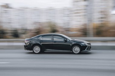Ukrayna, Kyiv - 23 Kasım 2021: Siyah Toyota Camry arabası sokakta hareket ediyor. Yazı