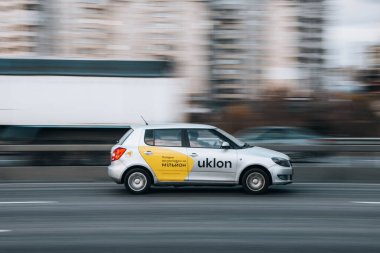 Ukrayna, Kyiv - 23 Kasım 2021: Beyaz Skoda Fabia Taxi Uklon arabası yolda ilerliyor. Yazı