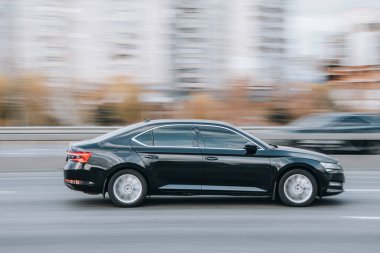 Ukrayna, Kyiv - 23 Kasım 2021: Siyah Skoda Superb arabası sokakta hareket ediyor. Yazı