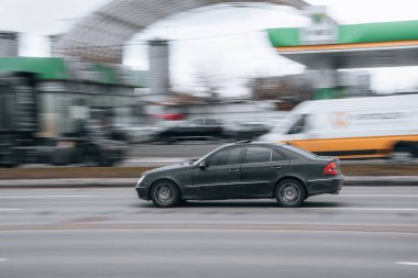 Ukrayna, Kyiv - 15 Ocak 2022: Siyah Mercedes-Benz E-Sınıfı araba yolda ilerliyor. Yazı