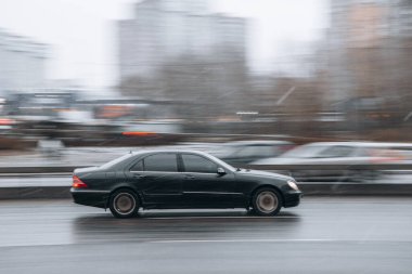 Ukrayna, Kyiv - 15 Ocak 2022: Siyah Mercedes-Benz S-Sınıfı araba yolda ilerliyor. Yazı