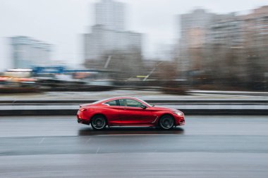 Ukrayna, Kyiv - 15 Ocak 2022: Kırmızı Infiniti Q60 arabası sokakta hareket ediyor. Yazı