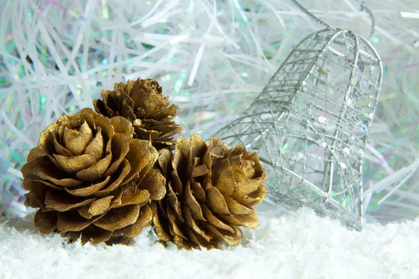 Cones de pinho dourado em um fundo branco nevado — Fotografia de Stock