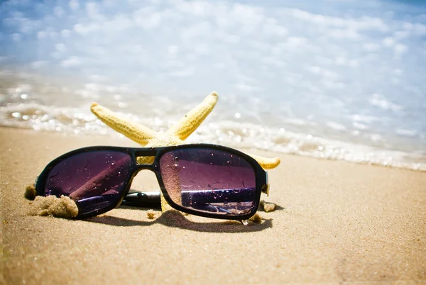 Seastar and sunglasses on a beach — Stock Photo, Image