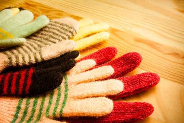 lot of knitted gloves on wooden background