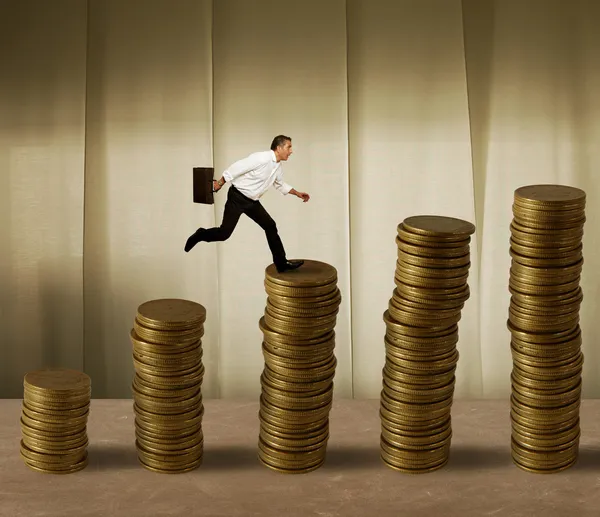 Прыгающий бизнесмен на деньги — стоковое фото