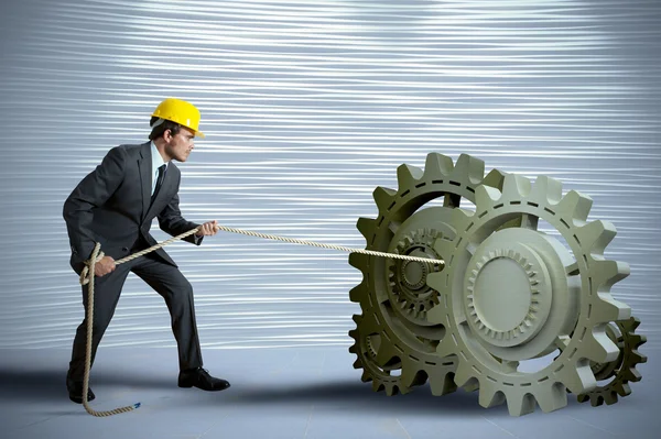 Businessman turning a gear system — Stock Photo, Image