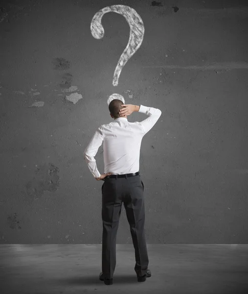 Confused businessman looking at question mark — Stock Photo, Image