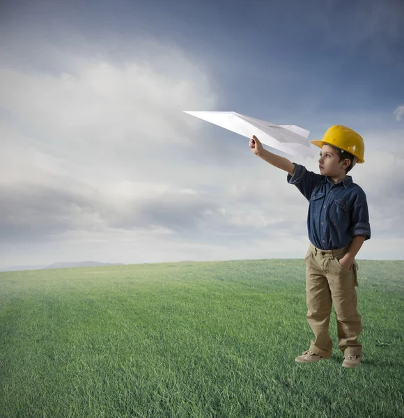 Young boy tries to fly a paper plane — Stock Photo, Image