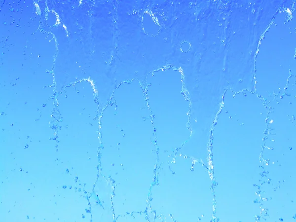Water drops of waterfall on blue sky — Stock Photo, Image