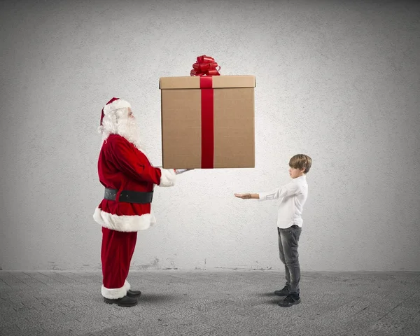 Santa claus met heden voor een kind — Stockfoto