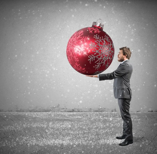 Homme d'affaires avec une grosse boule de Noël — Photo