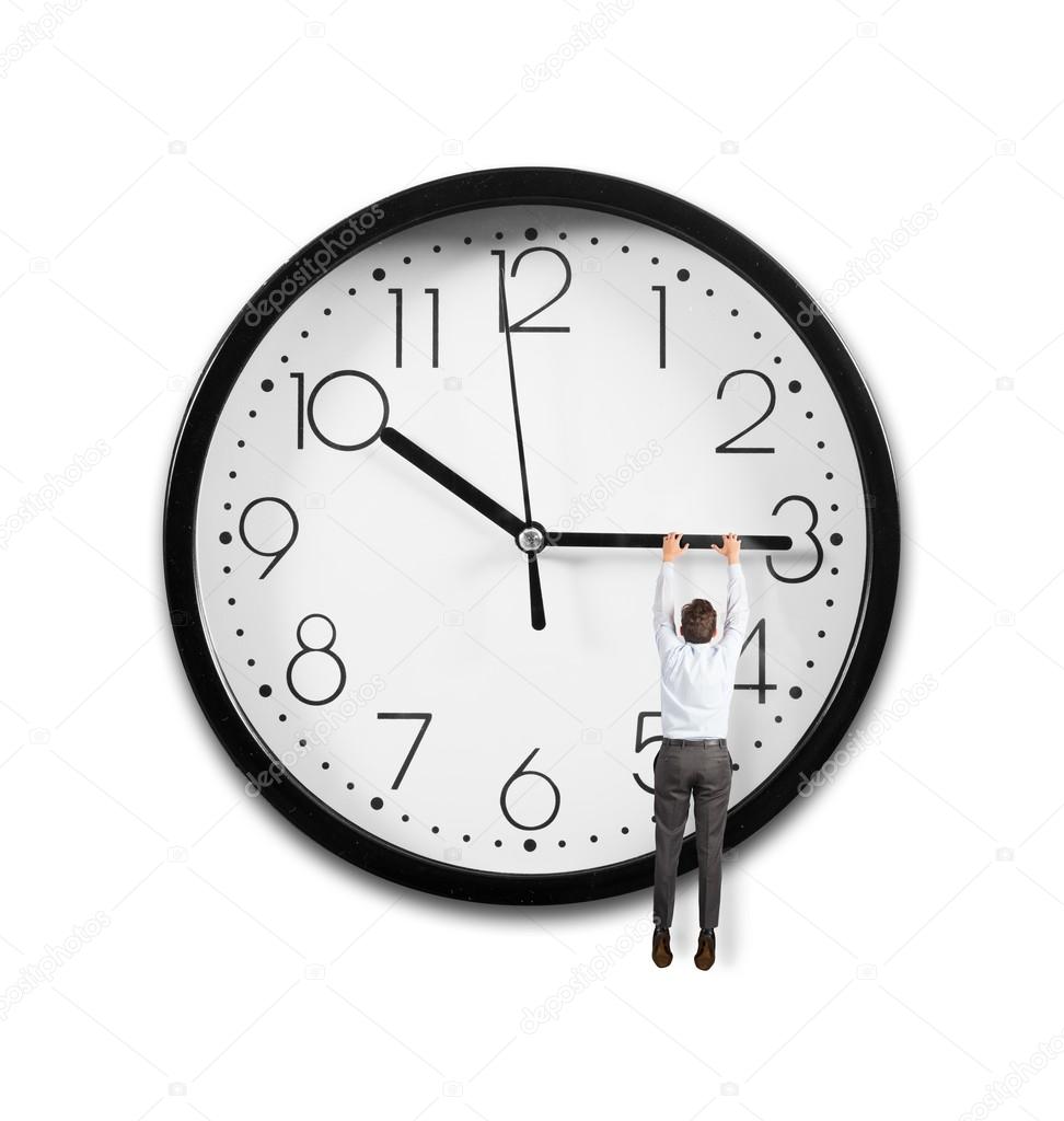 Businessman hanging from the hands of a clock