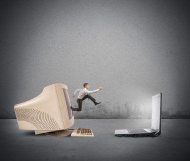 Businessman jumping from old computer to new laptop clipart