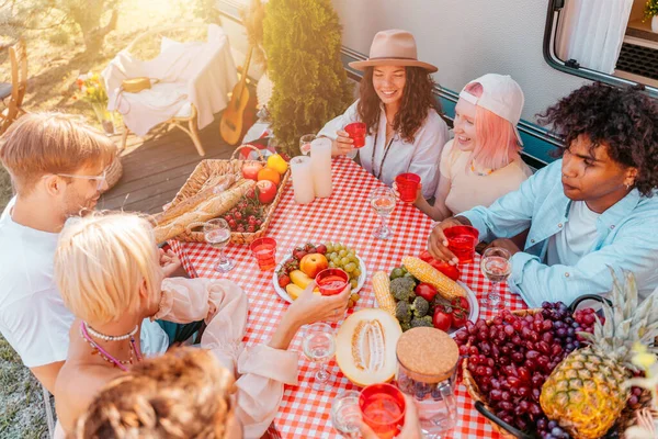 Przyjaciele urządzają piknik z kamperem w słoneczny dzień. — Zdjęcie stockowe