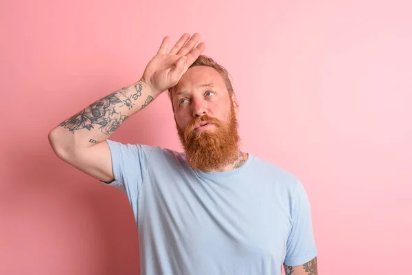 Uomo stanco con barba e t-shirt azzurra — Foto Stock