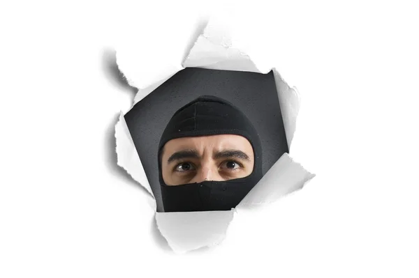 Thief looking through a paper hole — Stock Photo, Image
