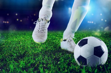Futbolcu stadyumdaki topa vurmaya hazır.