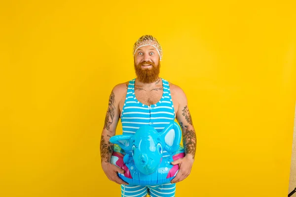 Verbazingwekkende man met reddingsboei en haarpet voor verbaasde vrouwen is klaar voor de zomer — Stockfoto
