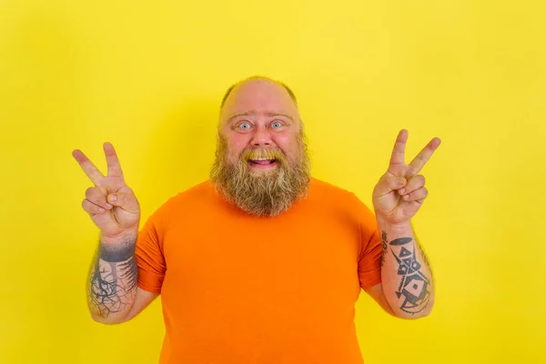 Hombre feliz con barba y tatuajes hace un gesto ganador con las manos — Foto de Stock