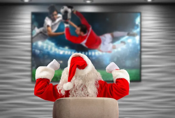 Feliz Papai Noel, fã de futebol, assiste a um jogo na televisão — Fotografia de Stock