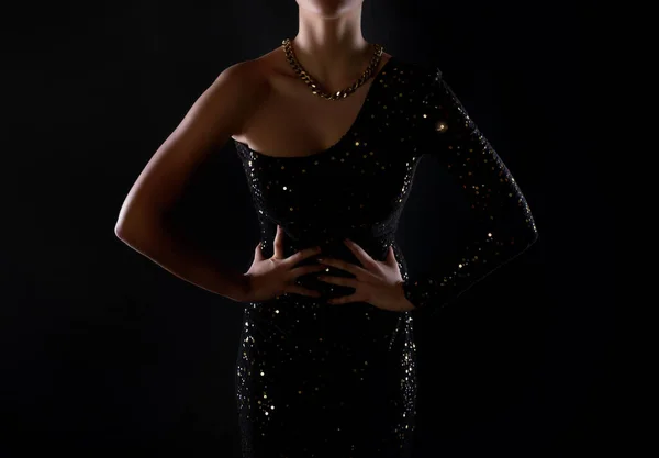 Το μοντέλο φοράει ένα μαύρο και χρυσό βραδινό φόρεμα elegan — Φωτογραφία Αρχείου