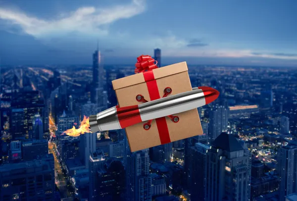 Julklapp flyger snabbt med en power raket över en stad — Stockfoto