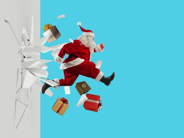 Père Noël plein de cadeaux sort briser un mur — Photo