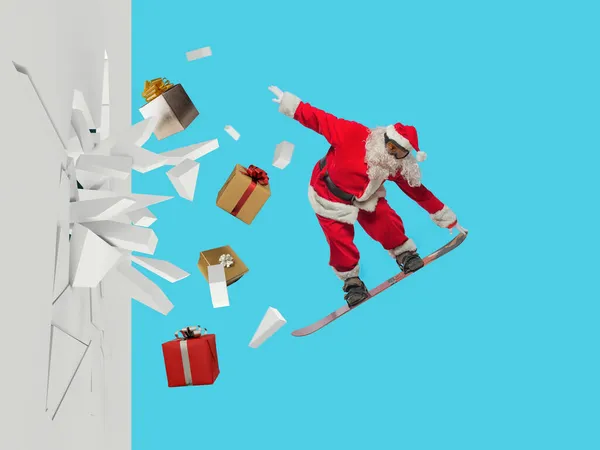 Santa Claus llena de regalos sale rompiendo una pared —  Fotos de Stock