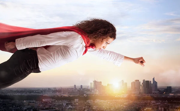 Mulher age como um super-herói voando sobre a cidade — Fotografia de Stock