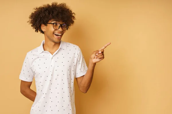 Homem feliz com óculos indica algo com a mão — Fotografia de Stock