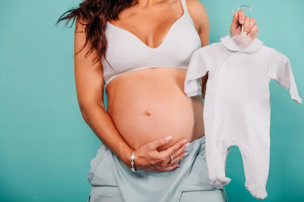 Mãe grávida prepara as roupas para o bebê — Fotografia de Stock