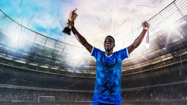 A kék egyenruhás focista örül a győzelemnek a stadionban. — Stock Fotó