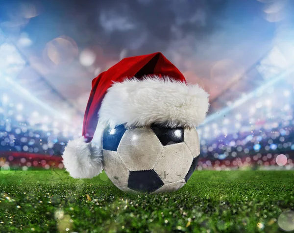 Soccer ball in a stadium with the Christmas hat — Stock Photo, Image
