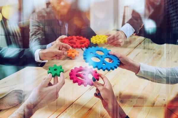 Business team connect pieces of gears like a teamwork and partners — Stockfoto