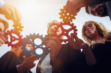 İş ekibi takım çalışması ve ortak olarak vites parçalarını birbirine bağlıyor