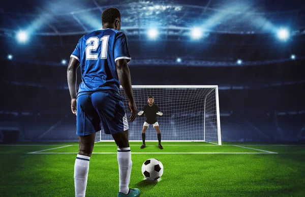 Escena de fútbol en el partido de noche con el jugador en uniforme azul pateando la patada penal — Foto de Stock