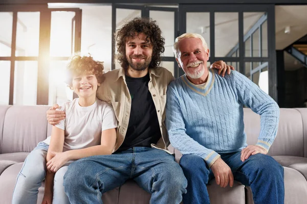 Grootvader, vader en kleinkind die samen genieten op de bank thuis — Stockfoto
