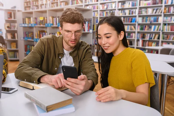 Universiteitsstudenten studeren samen in een bibliotheek als teamwork ter voorbereiding — Stockfoto