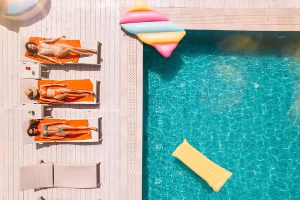 Groupe d'amis en maillot de bain boire un cocktail dans une piscine — Photo
