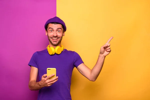 Uomo con smartphone è felice e indica qualcosa — Foto Stock