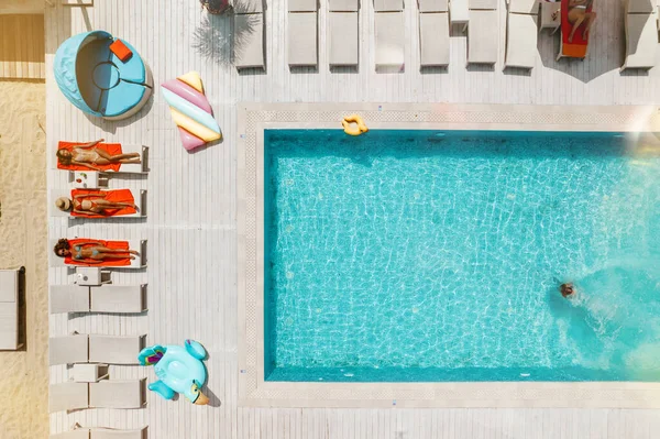 Вид с беспилотника на людей, расслабляющихся в бассейне от — стоковое фото