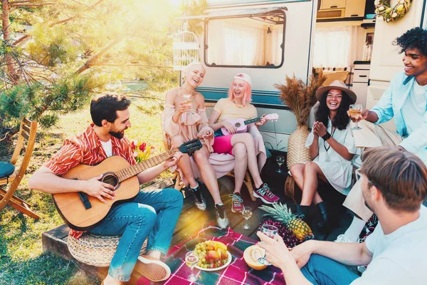 Przyjaciele mają piknik z kamperem i grać na gitarze — Zdjęcie stockowe
