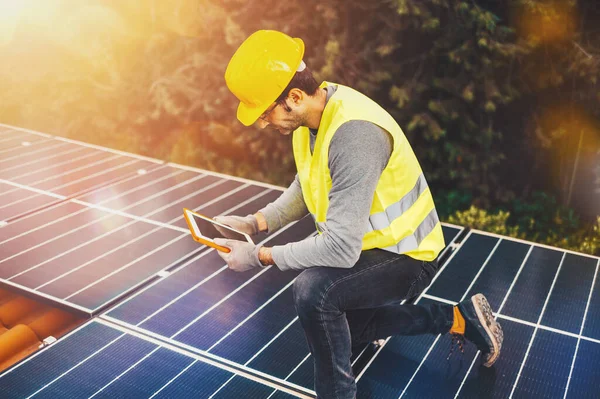 Los trabajadores verifican el sistema de energía con panel solar con una tableta —  Fotos de Stock