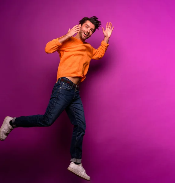 Homem feliz salta contra um fundo roxo — Fotografia de Stock