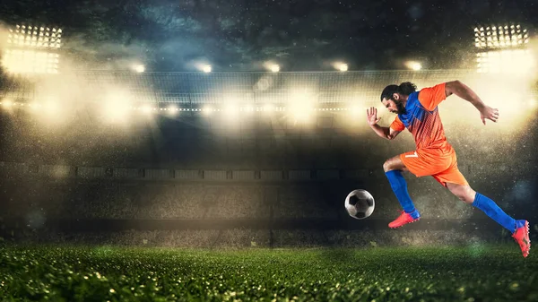 Jugador de fútbol en uniforme naranja y azul corriendo rápido con la pelota en el estadio — Foto de Stock